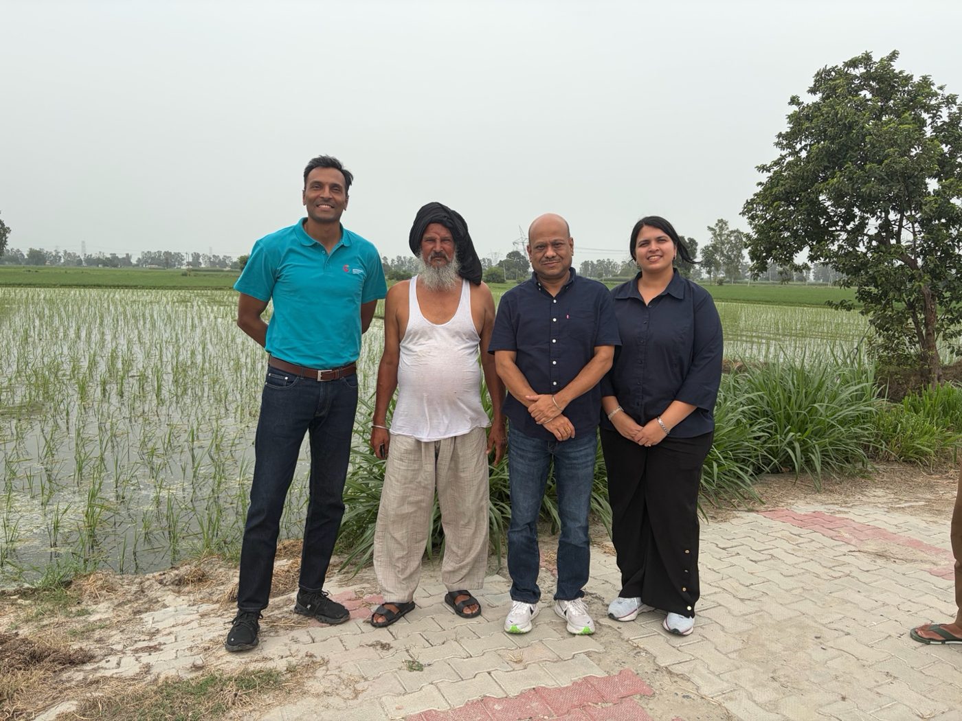 The Farsight team with a borrower beside his paddy field in rural northwest India